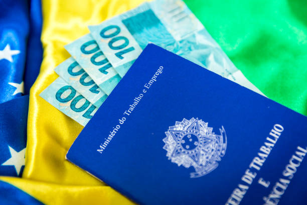 istock Brazilian work document and social security document (Portuguese: Carteira de Trabalho) on brazilian flag 696985924