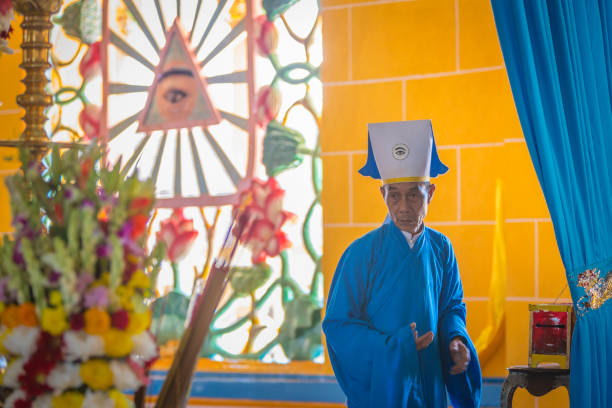 Tay Ninh, Vietnam  - November 23, 2015: A religious man who who participates in the Cao Dai ceremony at the Holy See temple in Tay Ninh, near Ho Chi Minh City (Saigon), southern Vietnam. Cao Dai is a syncretistic, monotheistic religion officially established in Tay Ninh in 1926, and mixes ideas from Confucianism, Taoism, Buddhism, and Roman Catholicism.