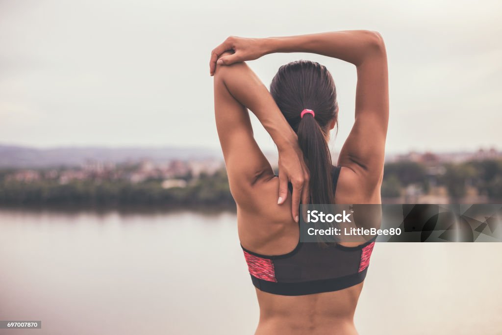 Sporty woman exercising Woman stretching and exercising outdoor.Image is intentionally toned. Stretching Stock Photo