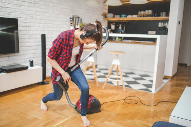 Playing an instrument Beautiful brunette woman, cleaning her home while listening to music. air guitar stock pictures, royalty-free photos & images