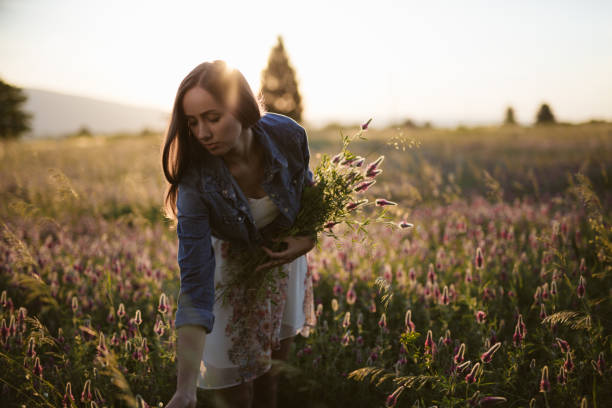 istock Woman in the flower field during sunset 697027366