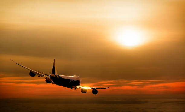 istock Airplane in the sky at sunset 697028032