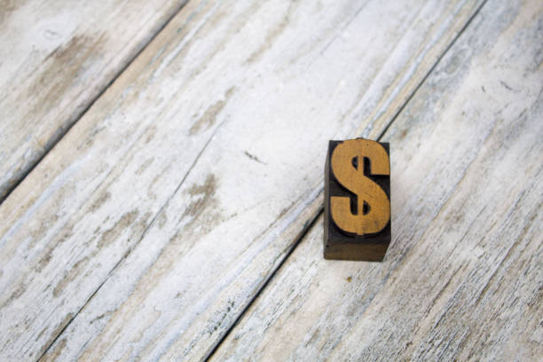 istock Letterpress Dollar Sign on Wooden Background 697028234