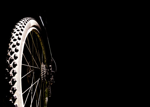 Bicycle wheel on a black background. Concept background