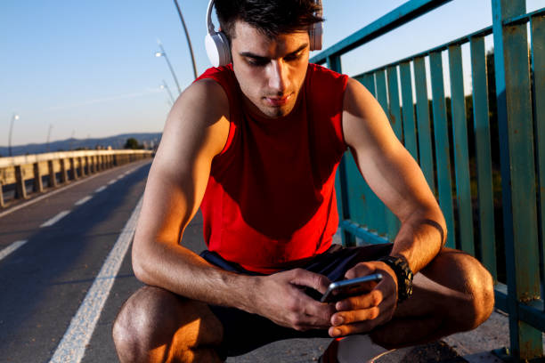 istock Portrait of young athlete man using mobile phone. 697037072