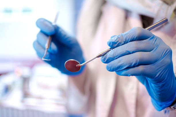 strumenti dentali nelle mani del medico. dentista in guanti di lattice sterili che tengono gli strumenti dentali, primo. - igienista dentale foto e immagini stock