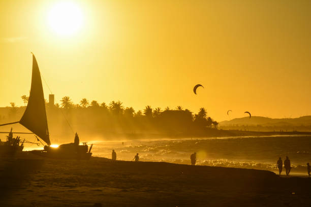 sonnenuntergang am strand von cumbuco. kite-surfer auf dem meer, bundesstaat ceara, brasilien - schichtvulkan stock-fotos und bilder