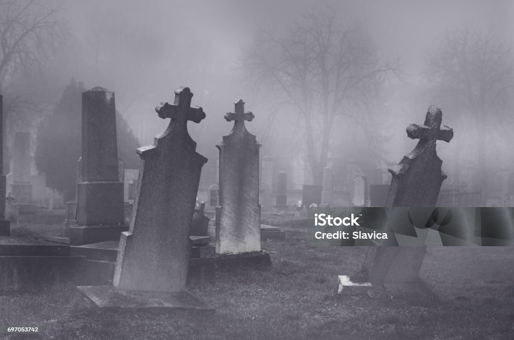 Old creepy haunted cemetery on foggy night Old creepy haunted cemetery on misty night. Cemetery Stock Photo