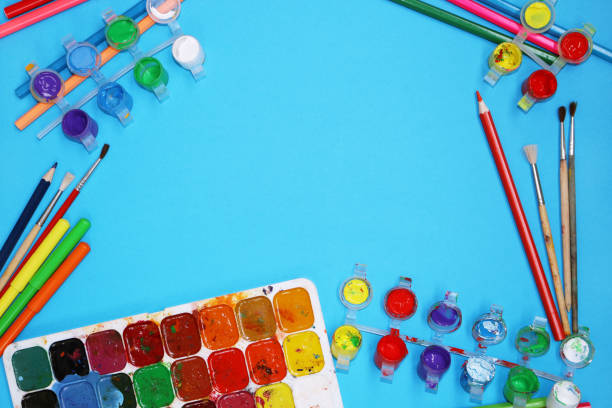 istock Watercolor Paints And Brushes on blue background 697054356