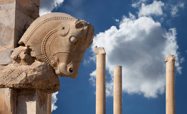 Persian Column with Bull Capital Against Blue Sky with White Fluffy Clouds from Persepolis of Shiraz in Iran stock photo