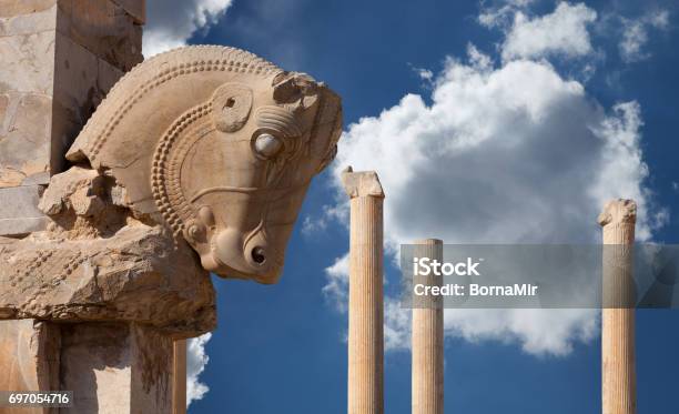 Persian Column With Bull Capital Against Blue Sky With White Fluffy Clouds From Persepolis Of Shiraz In Iran Stock Photo - Download Image Now