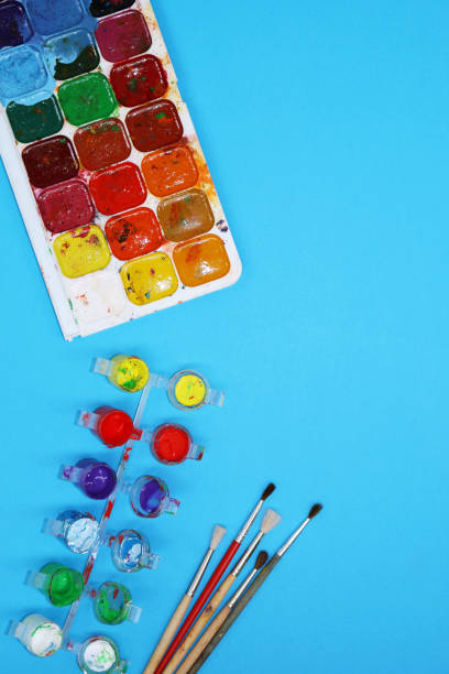 istock Watercolor Paints And Brushes on blue background 697057056