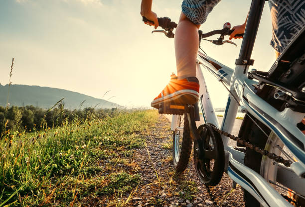 istock Boy feet in red sneackers on bicycle pedal close up image 697057948