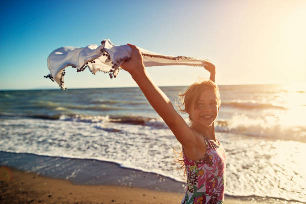 istock Little girl enjoying sunset on a windy beach 697060740