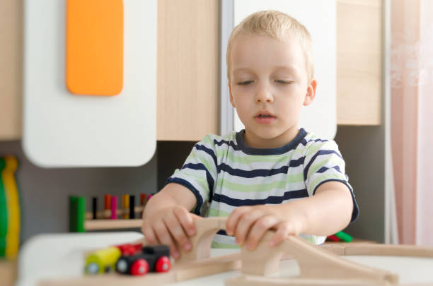 istock Child boy play with wooden train in kindergarten 697068694