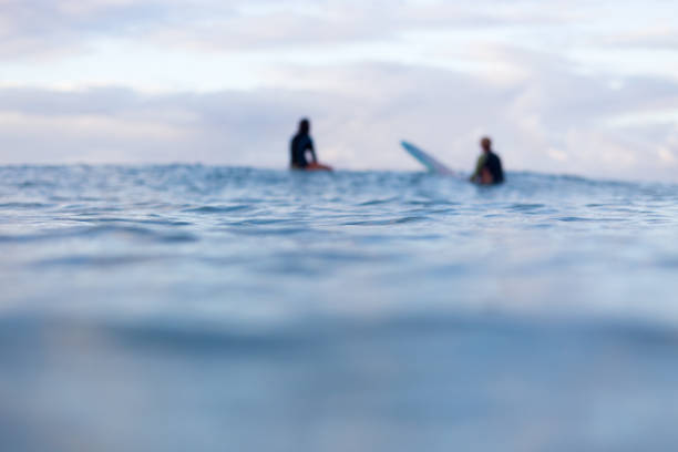 Out of focus surfers on the horizon stock photo