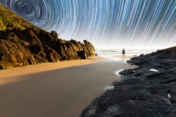 Person and coastal star trail stock photo