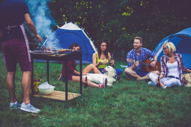 istock Man and three women on camping in nature 697122640