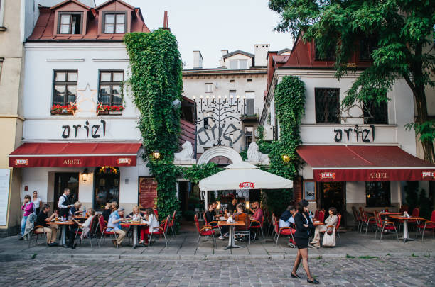 Krakow, Poland - June 28, 2016: People enjoy their meals in atmospheric cafe in Jewish quarter.