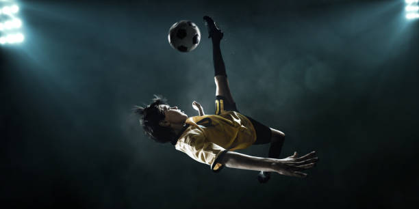 istock Soccer kids player kicking ball in spotlight 697123062