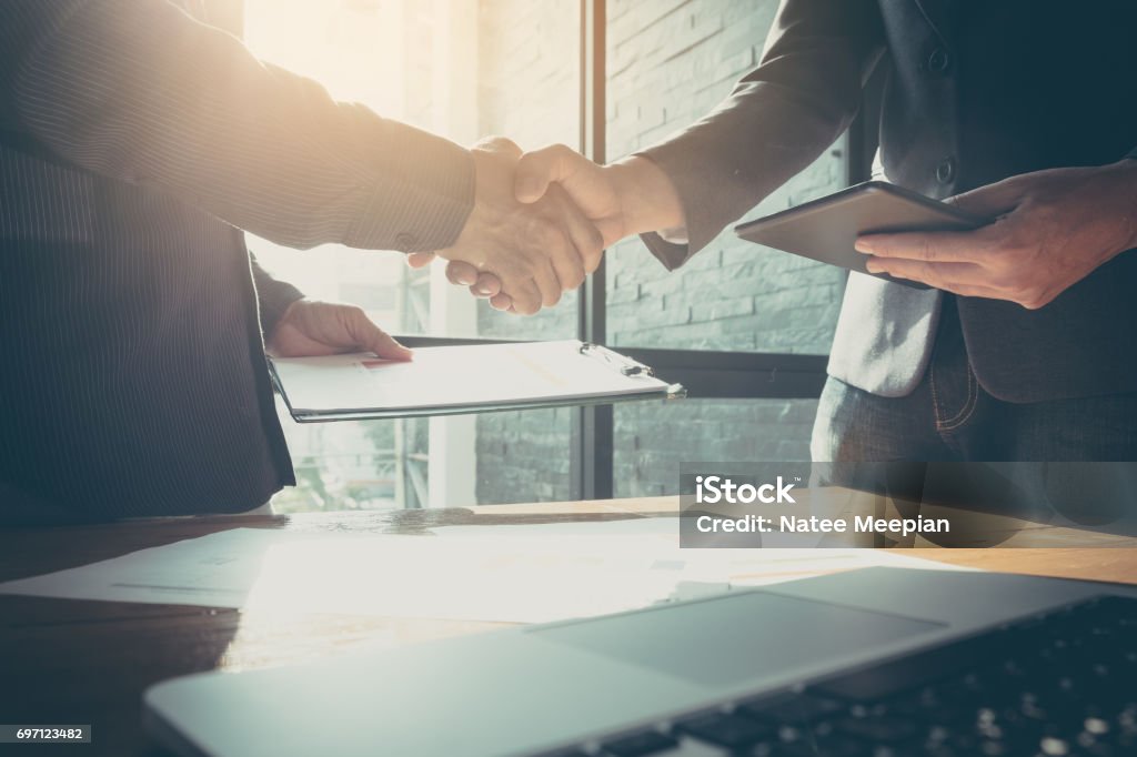 Businessman and partner shaking hands in office with vintage filter Job Interview Stock Photo