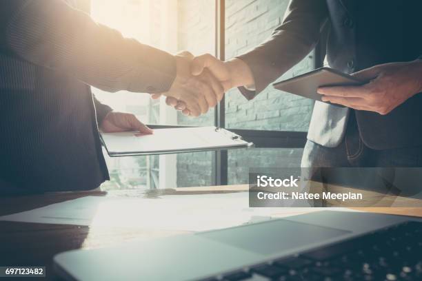 Businessman And Partner Shaking Hands In Office With Vintage Filter Stock Photo - Download Image Now