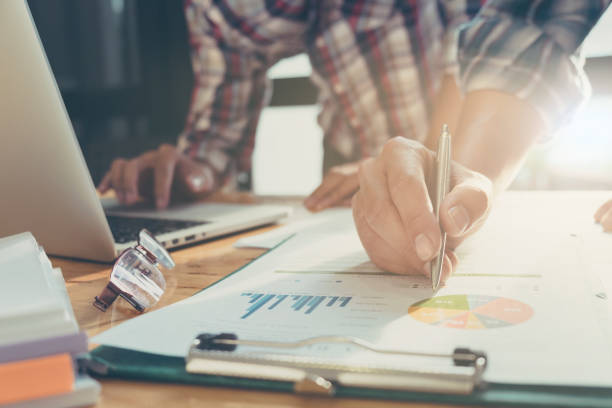 istock Business team analyzing income charts and graphs with modern laptop computer. close up business analysis and strategy concept. 697126296