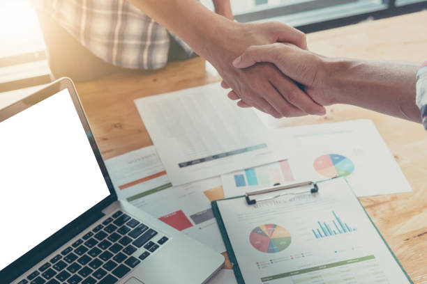istock Businessman and partner shaking hands in office 697127228