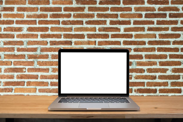 istock Laptop computer with blank screen with background of old vintage brick wall 697130604