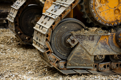 big crawler wheel, The Crawler close up , muddy crawler chain detail in earthy ambiance, Well used excavator tracks closeup