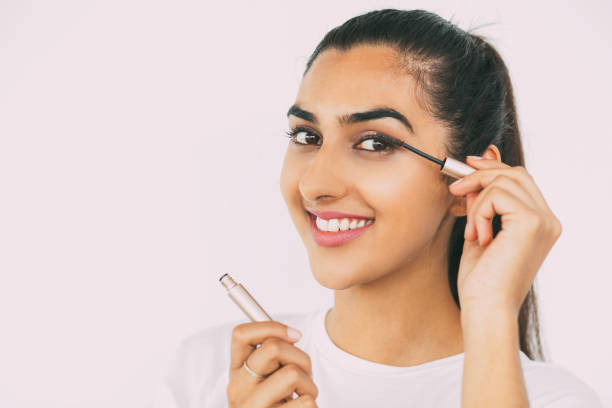 istock Smiling Beautiful Indian Lady Applying Mascara 697134534