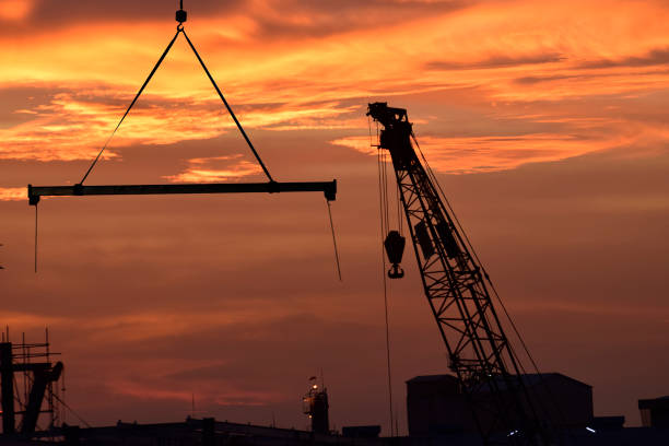 istock Silhouette tower cranes build large residential buildings  at construction site 697144200