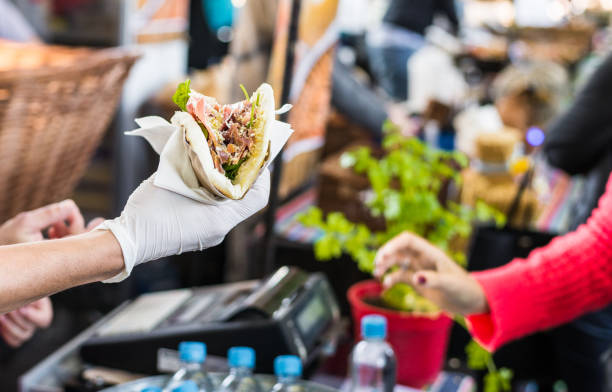 chef dando una tortilla a un foodie en un mercado de comida en la calle - caseta fotografías e imágenes de stock