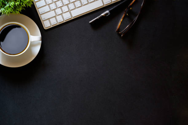 istock Modern dark surface office desk table with computer and cup of coffee 697149084
