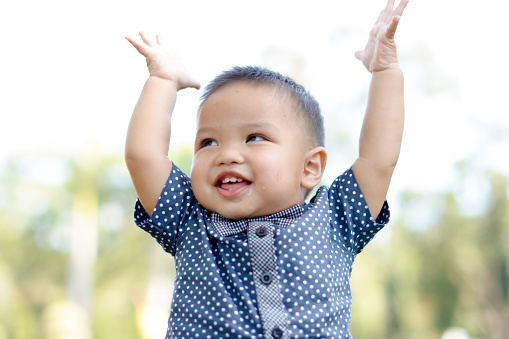 Cute asian boy raise hands and smile. Happy emotion