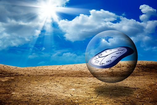 conceptual image of clock in glass ball floating in air