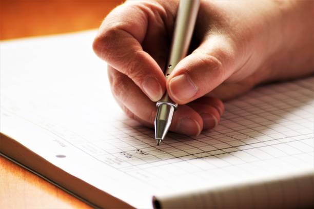 istock An Image of a Hand with pen - writing 697173008