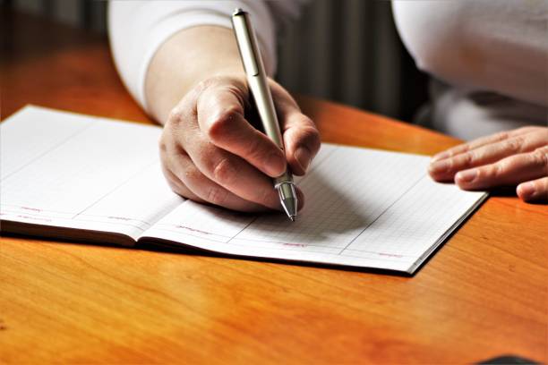 istock An Image of a Hand with pen - writing 697173034