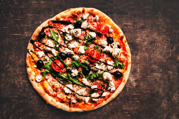 istock Fresh italian classic original pizza with cheese mozzarella,  pepperoni and salami on a rustic wooden table. 697173824