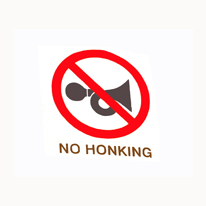 No Honking - No Horn sign board on a white background