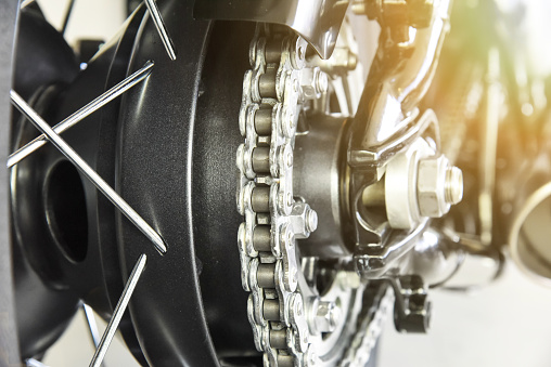 close up of motorcycle rear drive chain with selected focus shallow depth of field