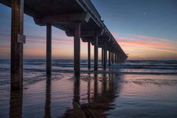 istock The sun setting over the Pacific Ocean, near a pier. 697207664