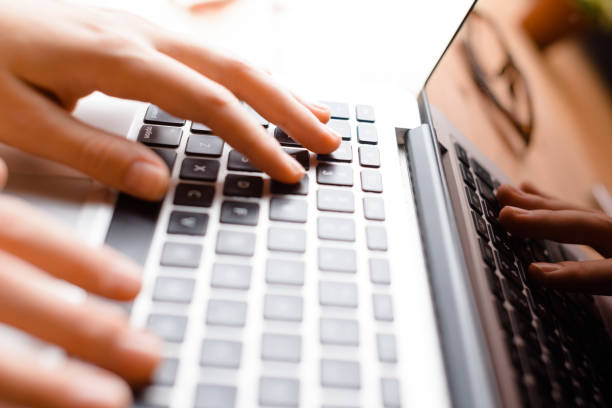 istock Hands working on the computer keyboard, pressing buttons, typing, simple close up with lens flare 697208116