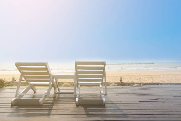istock Bench on the beach at yellow sunset 697214308