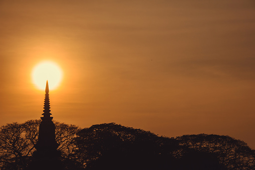 silhouette Thai pagoda (ayutthaya style) and tree bush in the sunset time, Ayutthaya, Thailand. vintage photo and film style