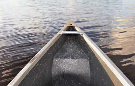 in front of a canoe navigate on a peaceful water  of a lake