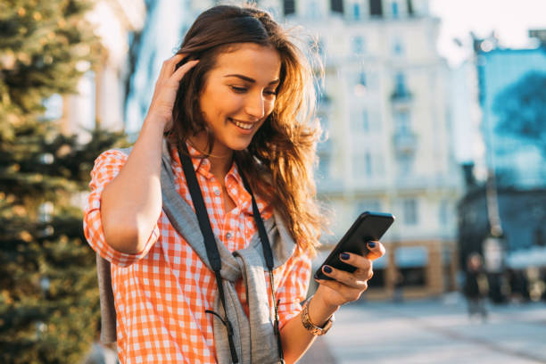 istock Beautiful woman texting outdoors 697225568