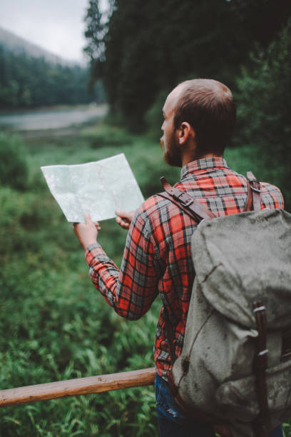 istock Man looking at the map near the forest in mountains 697228986