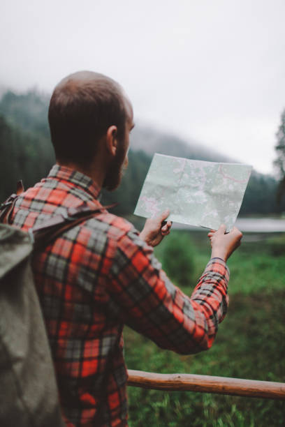 istock Man looking at the map near the forest in mountains 697231444
