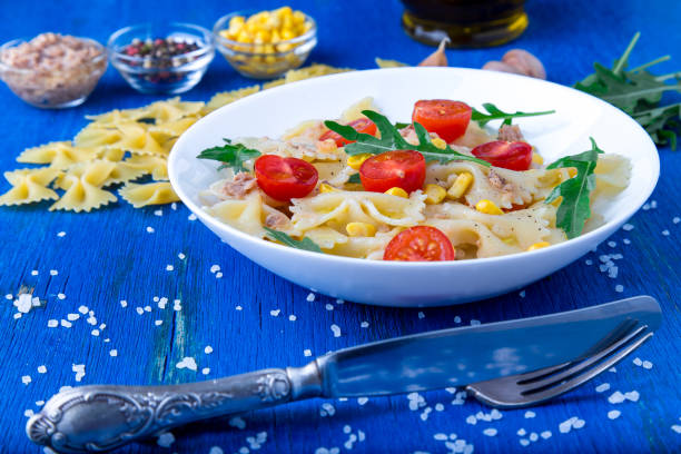 istock Pasta salad with tomatoes cherry, tuna, corn and arugula. Close up. 697232108